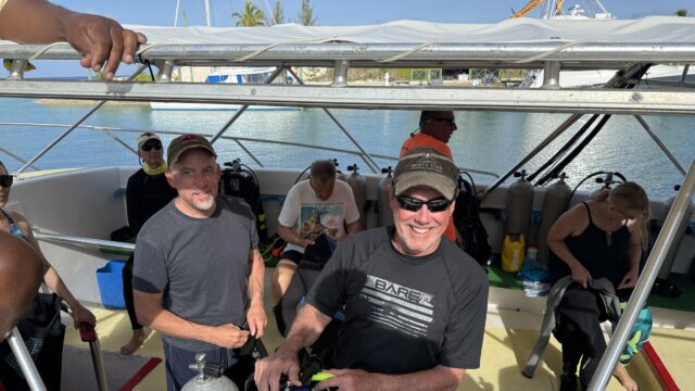 group of scuba divers preparing gear and equipment before entering the water